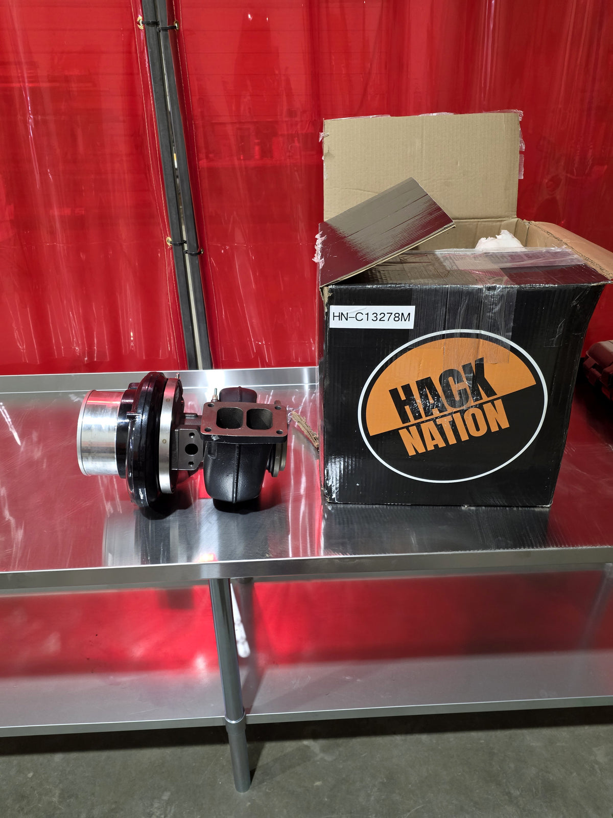 Hack Nation Stage 1 Turbo C15/3406-E (HN-C13278M) and box on shop table, full view